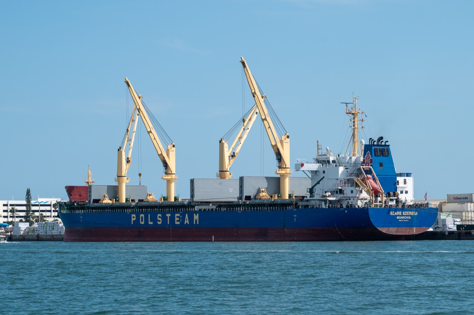 General cargo vessel with deck cranes under way